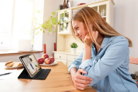 Pet owner using veterinary telehealth - XCura Mobile Vet Pet owner speaking with a veterinarian by video for telehealth pet care advice